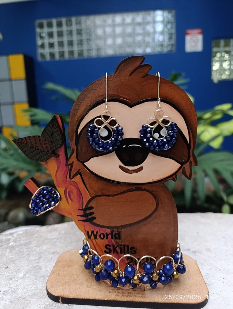 Handmade wooden sloth figurine wearing blue beaded sunglasses and necklace against blue classroom background