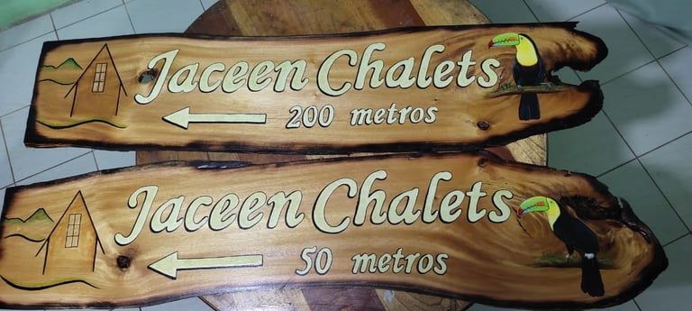 Two wooden directional signs for Jaceen Chalets indicating 200 metres and 50 metres distances