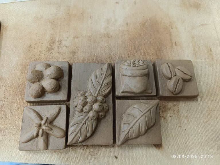 Six decorative stone relief tiles with carved botanical designs including flowers, leaves, and fruits